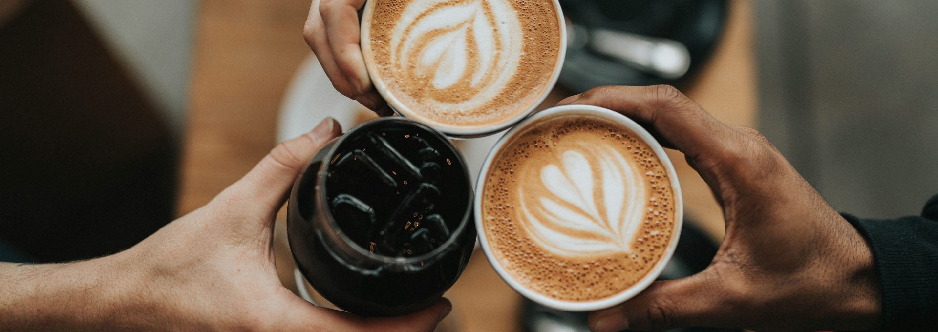 three person holding beverage cups