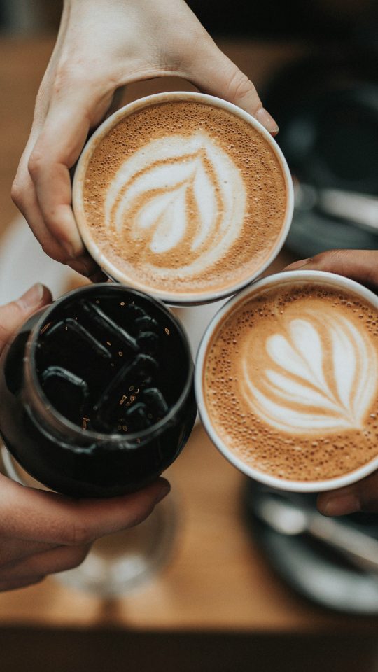 three person holding beverage cups