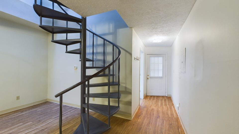 a spiral staircase in a hallway with hardwood floors at The Beacon Hill Apartments
